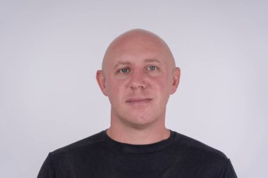 Kameraya bakan orta yaşlı, beyaz, kel bir adamın yakın çekimi. İnsanlar ve yaşam tarzı konsepti. İçerde orta yaşlı bir adamın portresi