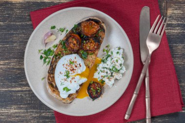 Kızarmış kırmızı domatesli haşlanmış yumurta, tabakta sarımsak ve süzme peynir, yakın çekim, üst manzara