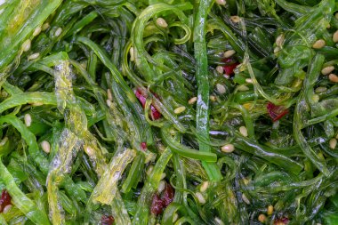 Arka planda susam tohumlu ve kırmızı biberli yosun salatası. Üst görünüm, kapat