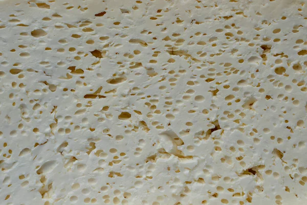 ハードコテージチーズはパルプの質感で半分にカットされます チーズスライスの背景を閉じます — ストック写真