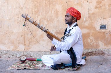 JAIPUR, INDIA - NOVEMBER 26, 2018: Hindistan 'ın eski kenti Jaipur, Rajasthan' daki Amber Fort yolunda turistler için Kamaycha adı verilen geleneksel müzik enstrümanında tanımlanamayan folk müzisyenleri çalıyor