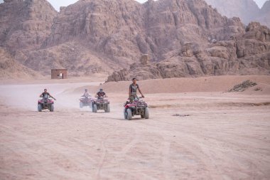 Sharm El Sheikh, Mısır - 19 Mayıs 2018: Sharm El Sheikh, Mısır yakınlarındaki çölde dört tekerlekli bisiklet safarisi. Güçlü hızlı off-road dört çekişli ATV 'ler, kumlu çölde motosikletler, yüksek dağlara karşı ralli