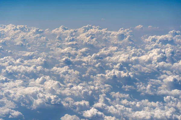Beyaz bulutlar ve gökyüzü, uçak penceresinden bir manzara. Doğa arkaplanı