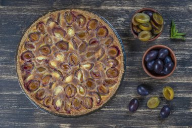 Ev yapımı organik erikli turta yenmeye hazır. Eski ahşap arka planda erik turtası, yakın plan.