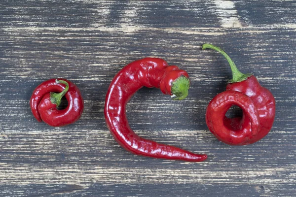 Tre Röda Varma Chili Paprika Gamla Trä Bakgrund Närbild Ovanifrån — Stockfoto