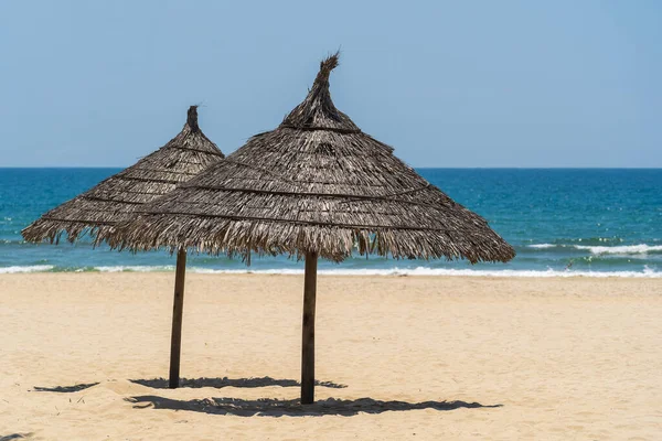 Песочный Пляж Летняя Морская Вода Голубым Небом Двумя Соломинками Городе — стоковое фото