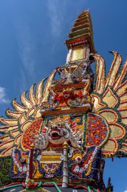 Endonezya 'nın Bali Adası' ndaki merkez caddede geleneksel iblis ve çiçek heykelleri bulunan Bade yakma kulesi. Yaklaşan yakma töreni için hazır. Kapat.