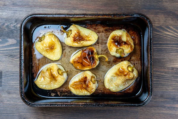 Fırınlanmış sarı biberler tavada, yakın çekim, üst manzara. Vejetaryen yemeği. Fırında ızgara sebze.