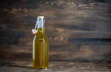 Ekstra saf zeytinyağı ahşap arka planda kırsal cam şişede, kapat, kopyala uzay