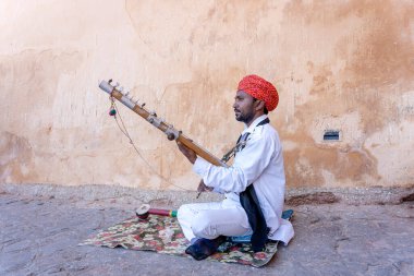 JAIPUR, INDIA - NOVEMBER 26, 2018: Hindistan 'ın eski kenti Jaipur, Rajasthan' daki Amber Fort yolunda turistler için Kamaycha adı verilen geleneksel müzik enstrümanında tanımlanamayan folk müzisyenleri çalıyor