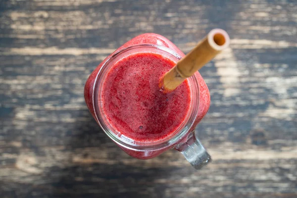 Cam kavanozda taze böğürtlen püresi ve ahşap arka planda bambu kamışı. Üst Manzara, kapat, kopyala alanı. Sağlıklı gıda konsepti