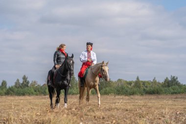 Slavuta, Ukrayna - 22 Eylül 2019: Ukraynalı erkek ve kız at sırtında Ukrayna 'nın Slavuta kentindeki Kolodar Etnik-çevre festivaline katıldılar