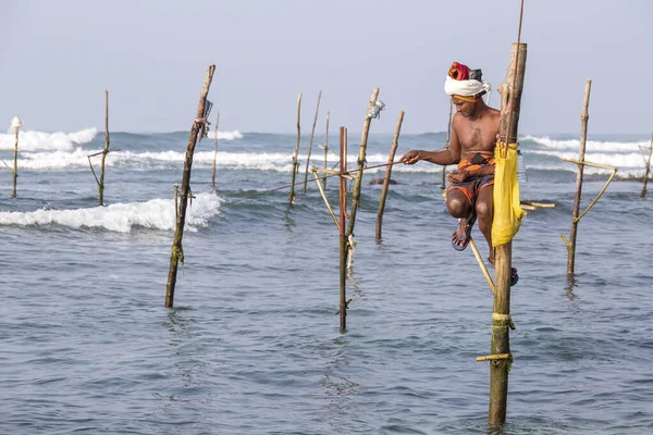 KOGALA, SRI LANKA - 9 Kasım 2014: Yerel balıkçılar tahta levhalarda oturur ve okyanusta balık yakalarlar. Hint Okyanusu 'nda Güney Sri Lanka için bu tür balık avı gelenekseldir.