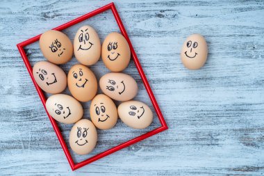 Kırmızı çerçeve ve beyaz ahşap duvarda gülümseyen bir sürü komik yumurta hayal edin. Yumurta ailesinin duygusal yüz portresi. Komik yemek kavramı. Boşluğu kopyala