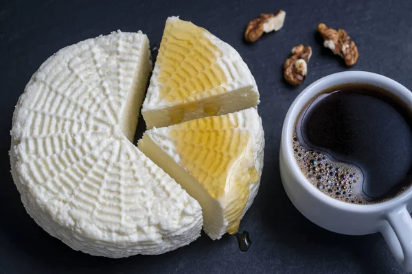 Homemade soft white cheese with white cup coffee, honey and walnuts on black slate background, close up, top view. Home cheese making. Adyghe cheese from milk — Stock Image Homemade Soft White Cheese White Cup Coffee Honey Walnuts Black Royalty Free Stock Photos