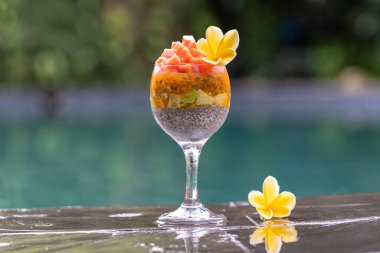 Papayalı Chia tohumu pudingi, tutku meyvesi, mango ve avokado kahvaltıda yüzme havuzu suyunun arka planında, yakın çekim. Sağlıklı beslenme, süper yemek kavramı.