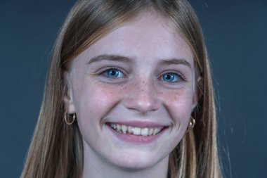 Siyah arka planda çilli güzel sarışın kız, portreyi kapat.