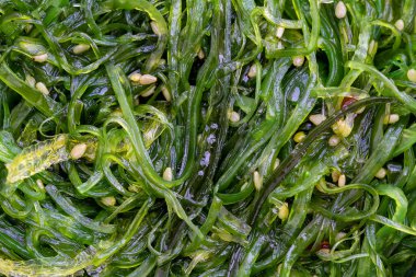 Arka planda susam tohumlu ve kırmızı biberli yosun salatası. Üst görünüm, kapat