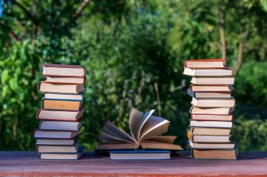 Ahşap masanın üzerine kitap yığını. Arka plan, açık hava. Kapatın.