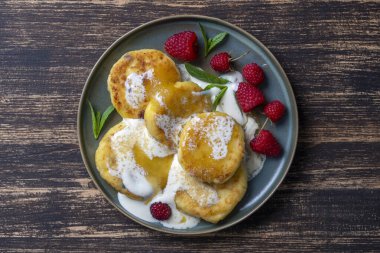 Naneli peynirli kek, ahududu, bal ve ekşi krema. Lezzetli tatlı, Ukrayna yemeği. Kapat, üst görünüm