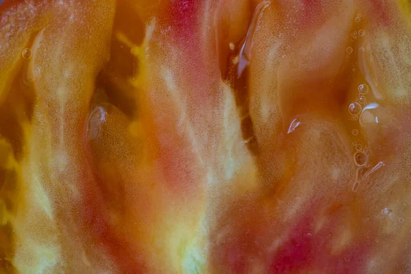 種子とパルプの質感を半分にカット赤黄色のトマト トマトスライスの背景を閉じ トップビュー — ストック写真