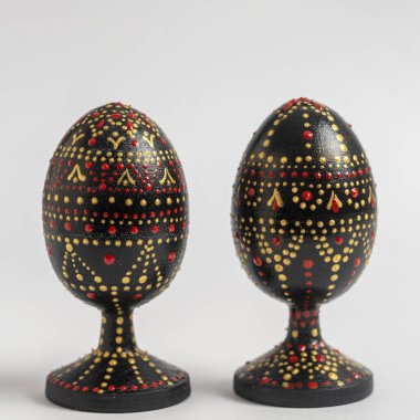 Beyaz arka planda el yapımı, ahşap bir paskalya yumurtası. El boyaması Paskalya, akrilik boyalı iki yumurta, el işi, nokta boyası, yakın plan, Ukrayna