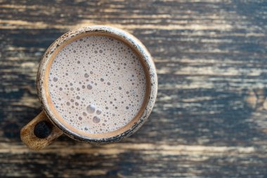 Ahşap arka planda bir kupa çikolatalı milkshake. Üst görünüm, kapat, boşluğu kopyala