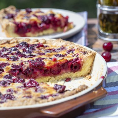 Ev yapımı vişneli turta. Bahçedeki ahşap masada. Kırsal arka planda.