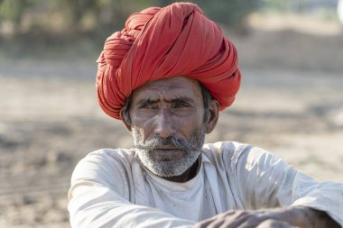 PUSHKAR, INDIA - 17 Kasım 2018: Hindistan 'ın kutsal şehri Pushkar, Rajasthan yakınlarındaki Pushkar Camel Mela sırasında çöldeki Hintli adam. Bu fuar dünyanın en büyük deve ticaret fuarı..