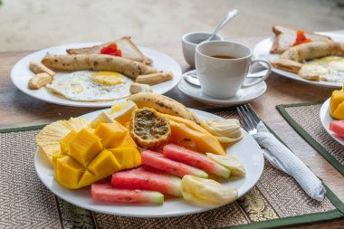 Otel restoranında, Zanzibar adasında, Tanzanya 'da, Afrika' da, deniz kenarındaki sahilde, meyveli, kahveli ve muzlu gözlemeli tropik kahvaltı.