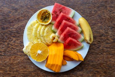 Kahvaltı tabağında tropik meyveler, yakın çekim. Taze karpuz, tutku meyvesi, ananas, Jackfruit, mango, muz, papaya, plaj restoranında yemek için portakal, ada Zanzibar, Tanzanya, Afrika