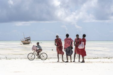 Zanzibar, Tanzanya - 12 Aralık 2019: Geleneksel giysiler giymiş Afrikalı grup masai, Zanzibar, Tanzanya, Doğu Afrika 'da, kumsalda, okyanus kıyısında duruyor.