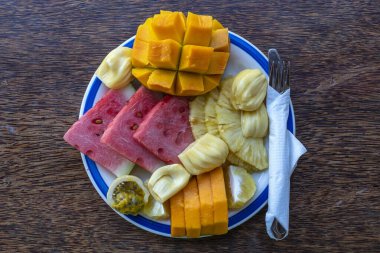 Kahvaltı tabağında tropik meyveler, yakın çekim. Taze karpuz, tutku meyvesi, ananas, Jackfruit, mango, papaya, plaj restoranında yemek için portakal, ada Zanzibar, Tanzanya, Afrika
