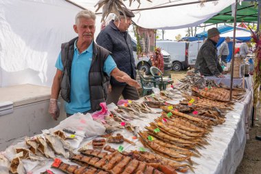 Slavuta, Ukrayna - 22 Eylül 2019: Ukraynalı adam Ukrayna 'nın Slavuta kentinde düzenlenen Etno-eko festivalinde füme balık sattı