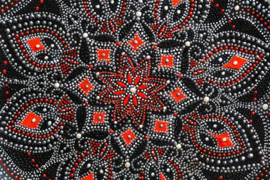 Kırmızı ve gümüş renkli dekoratif seramik tabaklar, arka planda boyalı tabaklar, yakın plan, üst manzara. Akrilik boyalarla boyanmış dekoratif porselen tabaka, el işi, nokta boyası.