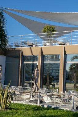 BATUMI, GEORGIA - 28 Ekim 2018: Batumi, Gürcistan 'da deniz kenarında bir sokak kafesinde şemsiyeli masa ve sandalyeler. Batumi, Gürcistan 'ın en çok ziyaret edilen turizm beldelerinden biri..