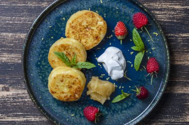 Naneli peynirli kek, ahududu, bal ve ekşi krema. Lezzetli tatlı, Ukrayna yemeği. Kapat, üst görünüm