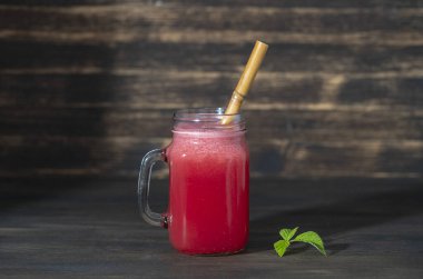 Ahşap arka plandaki cam kavanozda taze karpuz smoothie var, kapat. Sağlıklı gıda konsepti