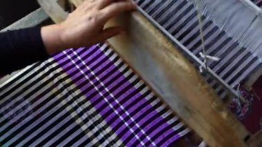 Yaşlı kadınların ahşap dokuma tezgahlarında ve ipek ya da pamuk kumaş üreten ipliklerle çalıştığı el sanatları köyünde geleneksel Vietnamlı tekstil üretimi. Sapa bölgesi, Kuzey Vietnam, kapatın.