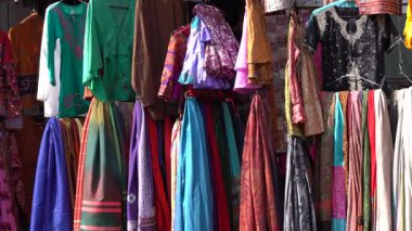 Udaipur, Rajasthan, Hindistan 'daki yerel sokak pazarında satılık renkli kıyafetlerin çeşitli ürünleri. Kapat.