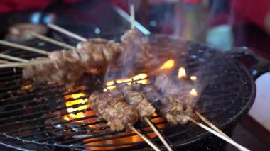 Sokak satıcısı Endonezya Bali 'deki sokak yemekleri pazarında ızgara tavuk eti satıyor. Asya mutfağı. Kapat.