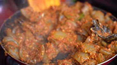 Soğanlı kızartma tavası, sığır midesi, kırmızı biber ve sos, yakın çekim. Endonezya 'da. Endonezya mutfağı, baharatlı sığır eti midesi buluşması ve limon otu yaprağı ve kırmızı biberli sos. Yemek pişirmek.