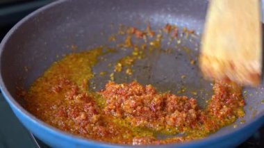 Tavada sebze yağında kızartılmış soğan, sarımsak ve kırmızı biber. Kızartma tavası, doğranmış soğan, sarımsak ve kırmızı biber, yakın çekim. Endonezya 'da. Yemek pişirmek.