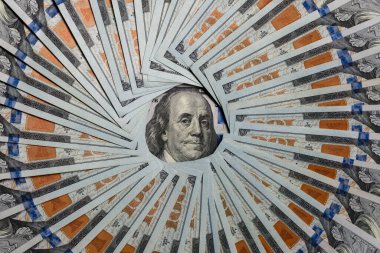 Circle made from american hundred dollar bills with image Benjamin Franklin in center, close up. American $100 bills, top view. Business, finance, cash and concept of saving money in United States