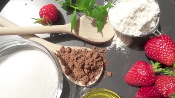 Сахар и мука рядом с какао и клубникой на подносе с мятой — стоковое видео