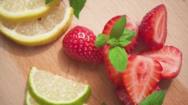 Dilimlenmiş limon ve buzlu bir sürahi yanında çilek