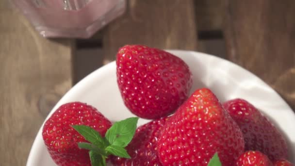 Erdbeeren in Zeitlupe auf einer Untertasse und Erdbeer-Smoothies — Stockvideo