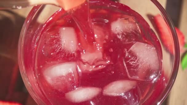 Le jus au ralenti est versé d'une cruche dans un verre avec un gros plan sur la glace — Video