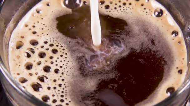 Lambat bergerak kopi di cangkir transparan untuk menuangkan susu — Stok Video
