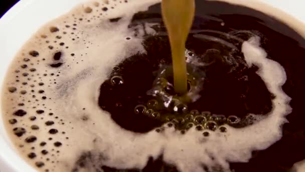 Un sottile flusso di caffè in una tazza bianca al rallentatore — Video Stock